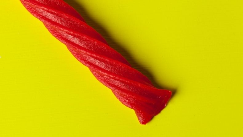Red strawberry twizzler on a yellow background